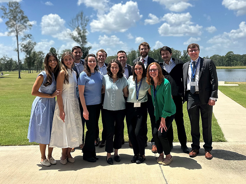 Outdoor group portrait of 12 residents at a conference.